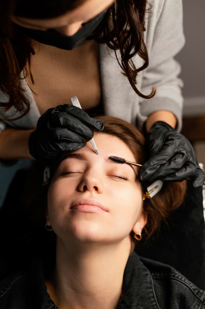 Brow and lash professional at work with an online booking calendar
